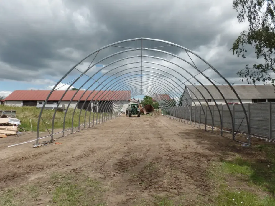 Szkielet hali namiotowej w gospodarstwie rolnym. Szkielet nie został jeszcze pokryty plandeką lub innym materiałem.
