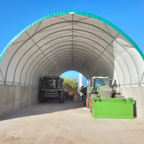 Namiot garażowy 10x30x1,5 m z betonowym murkiem wzmocnienia. Profesjonalna konstrukcja namiotowa z trwałym fundamentem.