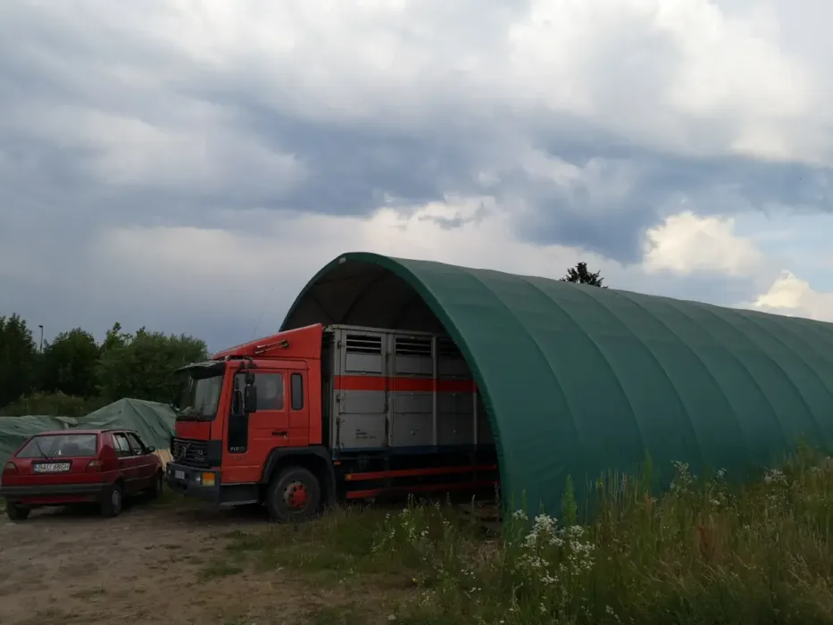 Namiot garażowy wykonany z hali namiotowej mieści w sobie ciągnik siodłowy z niską kabiną.