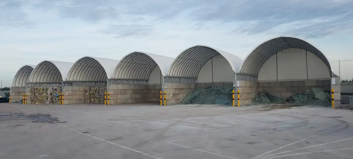 Ustawione w rzędzie hale łukowe przeznaczone do magazynowania odpadów do lub po sortowaniu.