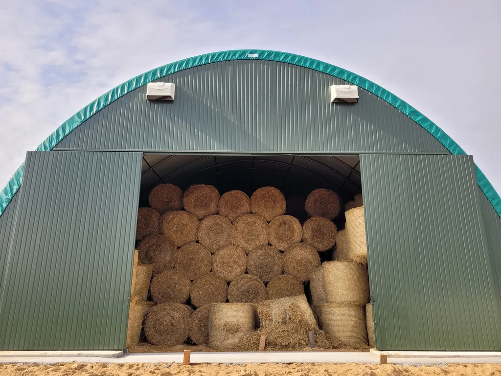 Zamknięta hala na baloty z pełnymi bramami szczytowymi zapewniająca wymogi bioasekuracji w gospodarstwie