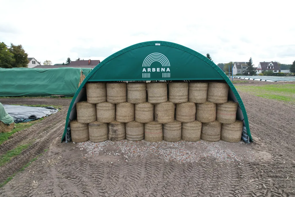 Szczyt hali na bale Arbena z siatką przeciwwietrzną chroniącą najwyższe warstwy słomy przed deszczem