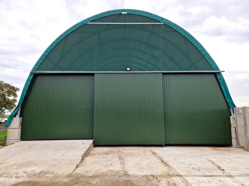 Zielona hala łukowa z zamkniętą bramą przesuwną